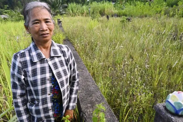 Bà Nguyễn Thị Vân đứng trước mộ gia đình = tháng 7 năm 2025, Bàn Tường, miền Trung Việt Nam (Kyodo)