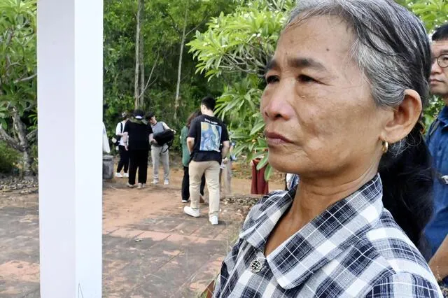 Bà Nguyễn Thị Vân rưng rưng nước mắt trước mộ gia đình = tháng 7 năm 2025, Bàn Tường, miền Trung Việt Nam (Kyodo)