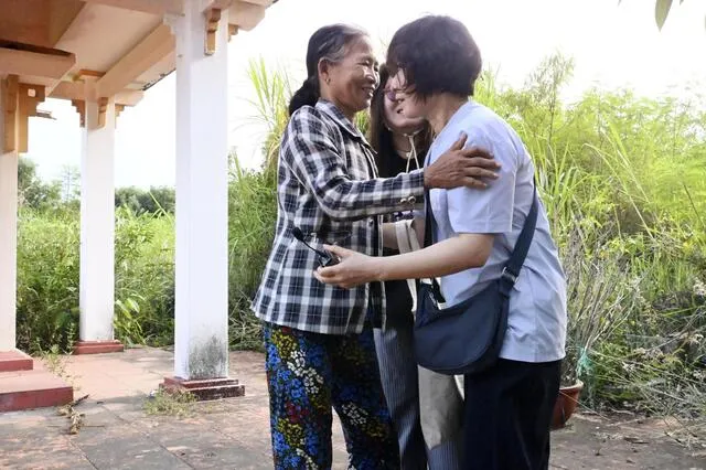 Bà Nguyễn Thị Vân (trái) ôm một công dân Hàn Quốc (phải) = tháng 7 năm 2025, Bàn Tường, miền Trung Việt Nam (Kyodo)