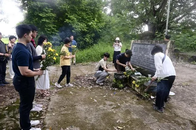 Các công dân Hàn Quốc đặt hoa tại bia tưởng niệm các nạn nhân vụ thảm sát = tháng 7 năm 2025, ngoại ô Đà Nẵng, Việt Nam (Kyodo)